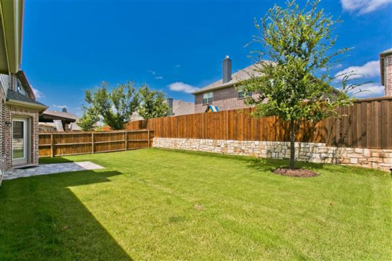    Large Grassy Back Yard with Tiled Patio 