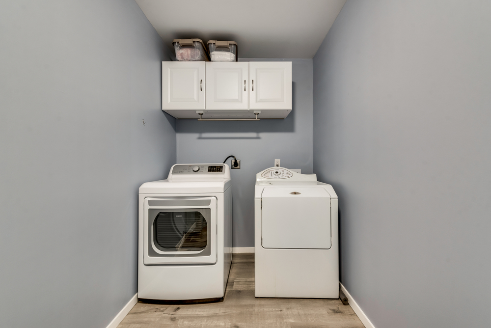    Spacious Utility Room with Pocket Door Built In Cabinetry and Room for Fridge 