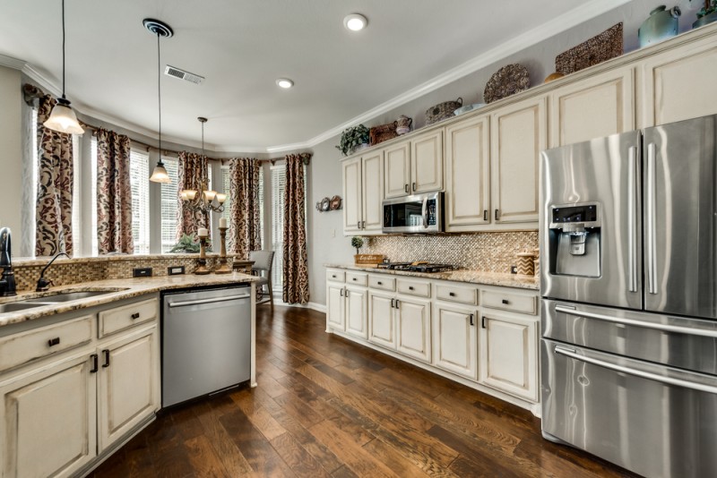    Abundance of Antiqued Cabinetry Granite and Stainless Steel Appliances 