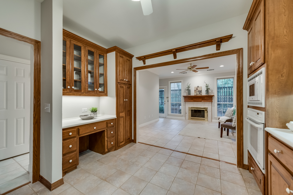    Kitchen features Built In Desk and Cabinetry with Glass Accented Front Doors 
